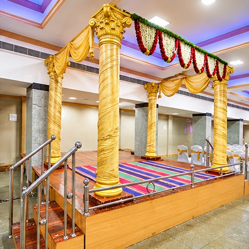 Gold-pillared manavarai decorated with jasmine and rose garlands